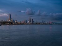 the water has very large chunks of blue in it and a skyline of large buildings in the background