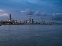 the water has very large chunks of blue in it and a skyline of large buildings in the background