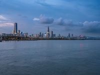 the water has very large chunks of blue in it and a skyline of large buildings in the background