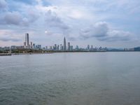 the water has very large chunks of blue in it and a skyline of large buildings in the background