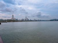 the water has very large chunks of blue in it and a skyline of large buildings in the background