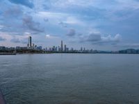 the water has very large chunks of blue in it and a skyline of large buildings in the background