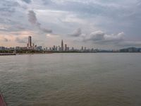 the water has very large chunks of blue in it and a skyline of large buildings in the background