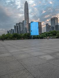 a very big square in the city with a view of it with blue glass building and skyscraper in the background