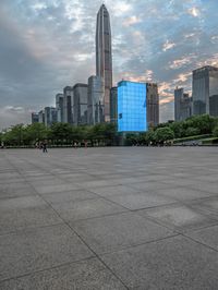 a very big square in the city with a view of it with blue glass building and skyscraper in the background