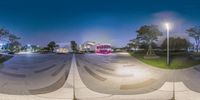 a 360 - fisheye image of an outside plaza with a person skating on it