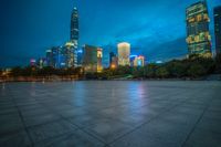 a cityscape lit up at night as the sun sets on the horizon in the background