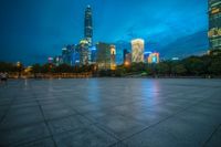 a cityscape lit up at night as the sun sets on the horizon in the background