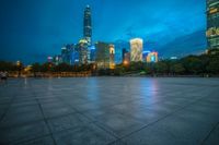 a cityscape lit up at night as the sun sets on the horizon in the background