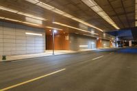 there is an empty street in the middle of a parking garage with lights and empty space