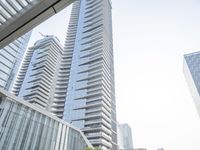 a couple of tall buildings standing next to each other in a city building area,