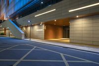 empty parking space and stairs inside the city at night time under lit up lights and windows