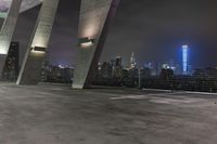 an industrial looking area is lit up at night with many tall buildings in the background