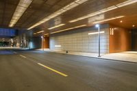 a dimly lit entrance to a modern building with wood paneling and concrete walls at night