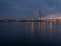 a bridge is seen during the sunset on a clear day with blue skies above it