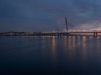 a bridge is seen during the sunset on a clear day with blue skies above it