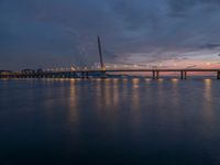 a bridge is seen during the sunset on a clear day with blue skies above it