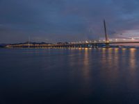 a bridge is seen during the sunset on a clear day with blue skies above it