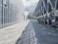 a walkway between two buildings in a big city with blue skies overhead and clouds above