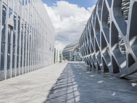 a walkway between two buildings in a big city with blue skies overhead and clouds above