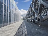 a walkway between two buildings in a big city with blue skies overhead and clouds above