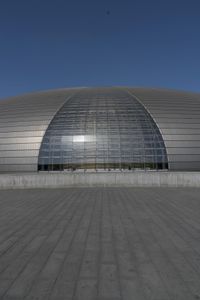 a person on a skateboard in front of a big building with a curved roof