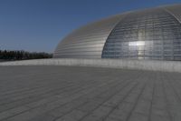 a person on a skateboard in front of a big building with a curved roof