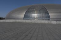 a person on a skateboard in front of a big building with a curved roof