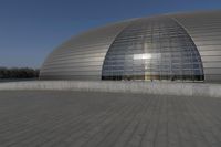 a person on a skateboard in front of a big building with a curved roof