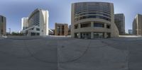 a very large concrete city building with lots of windows on it's sides and a circle