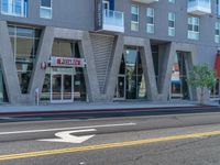 a woman riding a skateboard past a commercial building in an urban area of los