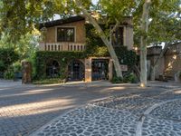 a manholed road with many trees in the middle of it and a building in the back