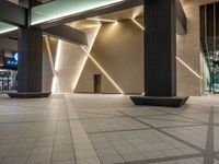 a hallway with columns on the wall that have led lights coming out of them and a door is behind the wall