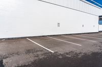 a parking lot with some signs near by a brick building with white paint on it