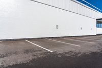 a parking lot with some signs near by a brick building with white paint on it