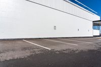 a parking lot with some signs near by a brick building with white paint on it