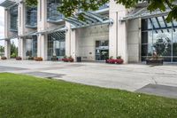 a sidewalk leading to a government building with flower display on the windows of the front entrance