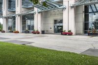 a sidewalk leading to a government building with flower display on the windows of the front entrance