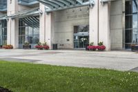 a sidewalk leading to a government building with flower display on the windows of the front entrance