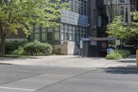 a sidewalk with no traffic on it near tall buildings and a street corner with trees