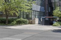 a sidewalk with no traffic on it near tall buildings and a street corner with trees