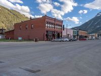 a red fire hydrant sitting in front of an old store window and building next to an open air field