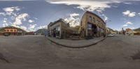 an 360 camera lens showing street in small town with shops on the street and buildings