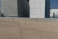 two skate boards are parked on a concrete area with the side of a building in the background