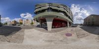 a picture taken through fisheye lens looking at a skate park near a building and parking lot