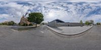 a fish eye image of a skate park in front of a church and church steeple