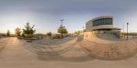 a large skate park in the back of the city building with its reflection on the concrete