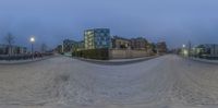 a 360 - angle image of an empty skate board park on a cloudy night with city lights