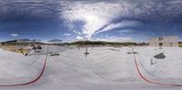 a group of skateboards ride on a ramp at a skate park under construction with clouds in the sky