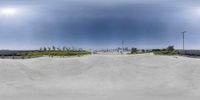 a large empty white skate ramp at a skate park with a blue sky in the background